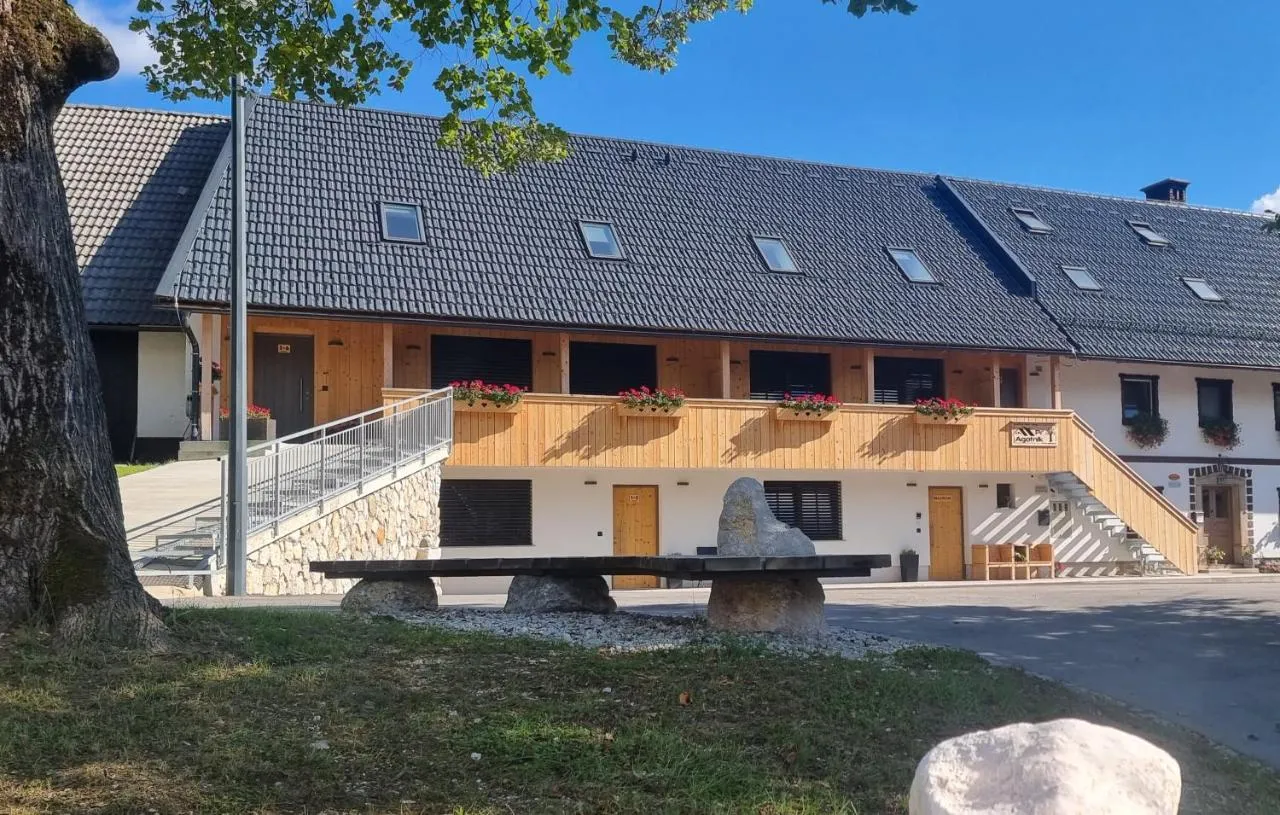 Hiša s parkirišča: zunanje stopnice in dolg lesen balkon v nadstropju
